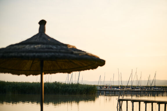 Sonnenuntergang Neuer Strand mit Strandschirm und Marina im Hintergrund