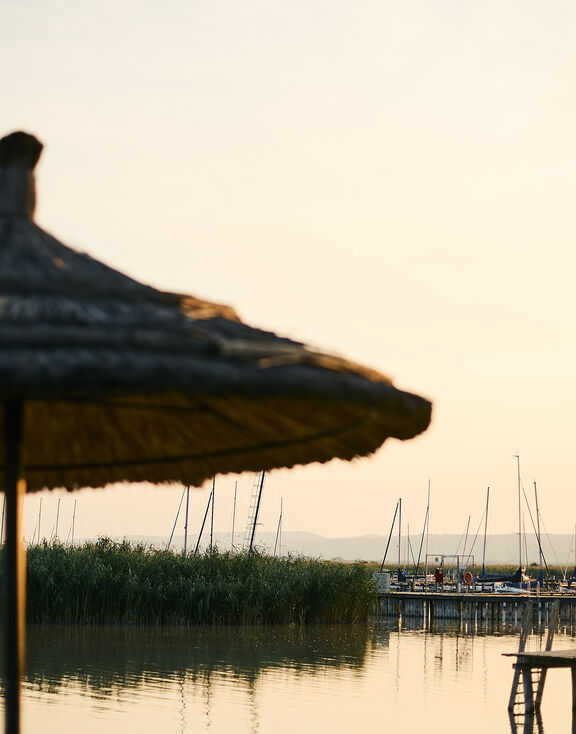 Sonnenuntergang Neuer Strand mit Strandschirm und Marina im Hintergrund